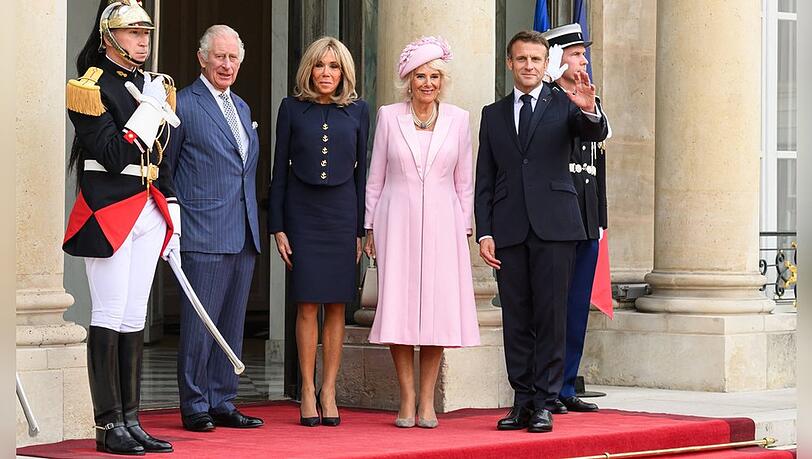 Emmanuel Macron (r.) empfängt König Charles III. in Paris - dazwischen nehmen die Gattinnen Stellung: Königin Camilla (r.) und Brigitte Macron.
