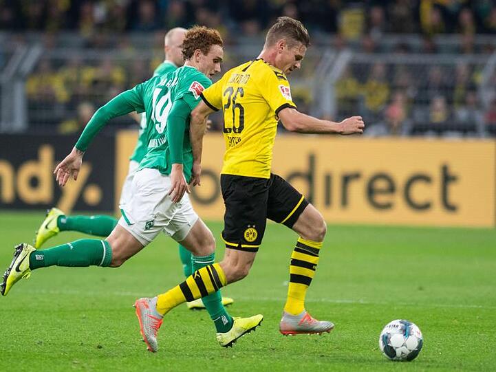 Dortmund Lukasz Piszczek (r) und Josh Sargent von Bremen versuchen, an den Ball zu kommen.