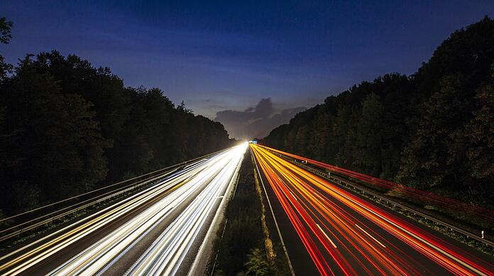 Von Wagen sind nur Lichter auf einer Autobahn zu sehen. Forscher wollen kabelloses Laden von E-Autos möglich machen.