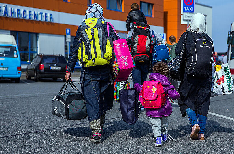 Eine Flüchtlingsfamilie geht zum Fährcenter im Hafen von Rostock