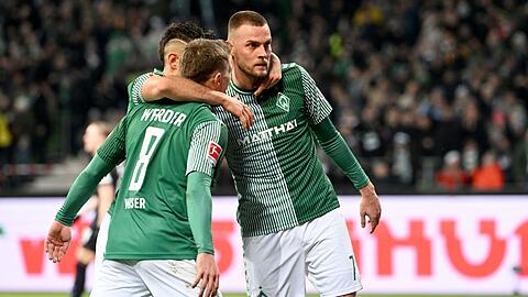 Werders Torschütze Marvin Ducksch (r) jubelt mit Mitchell Weiser und Rafael Borre.