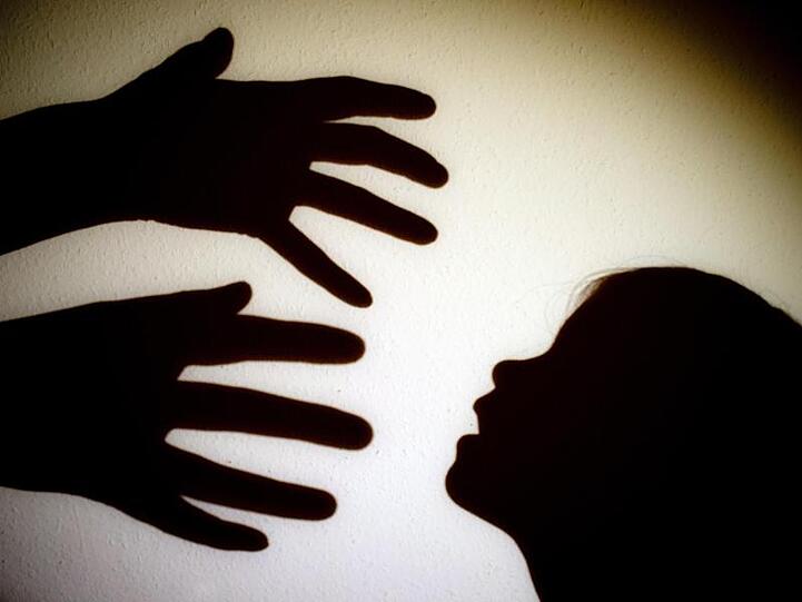 Schatten von Händen einer erwachsenen Person und dem Kopf eines Kindes an einer Wand. Foto: Patrick Pleul/zb/dpa/Illustration