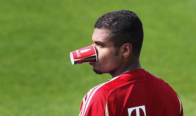 Breno hält einen Pappbecher mit dem Mund.