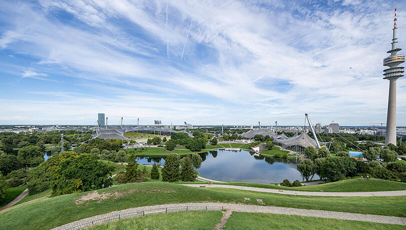 Der Olympiapark heute mit Turm, See und  Schwimmhalle.