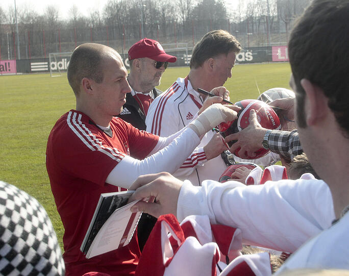 Umringt von vielen Fans schreibt Louis van Gaal Autogramme an der Säbener.