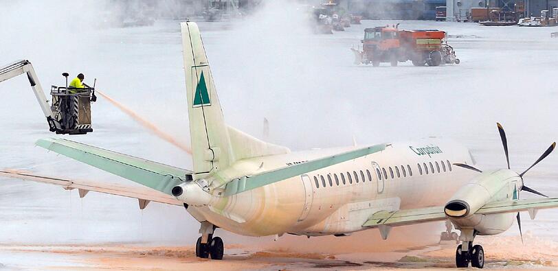 Schnee am Münchner Flughafen. Eine Maschine wird enteist. Hunderte Flüge mussten letzten Donnerstag, Freitag  und auch heute wieder gestrichen werden.
