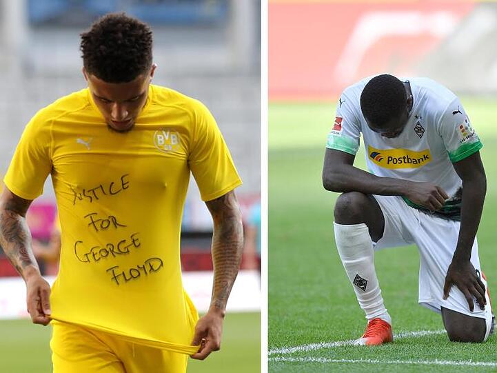 Dortmunds Jadon Sancho (l) trägt ein Trikot mit der Aufschrift "Justice for George Floyd", Der Gladbacher Marcus Thuram kniet auf dem Rasen.