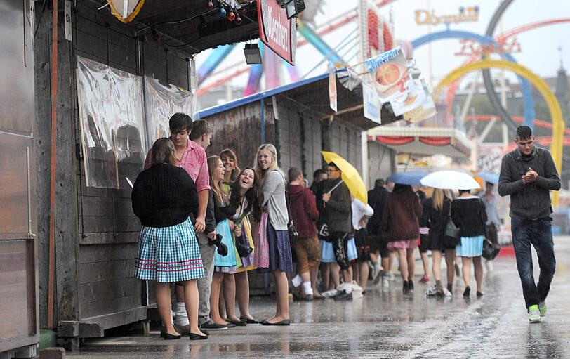 Trotz Sauwetter und Regen warten bereits viele Wiesngänger auf den Wiesnanstich. Der Kampf um den Platz im Bierzelt beginnt schon am frühen Morgen. Die ersten Bilder.