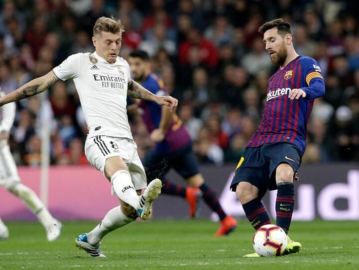 Auch für Toni Kroos (l) und Lionel Messi soll in Spanien der Ball bald wieder rollen.