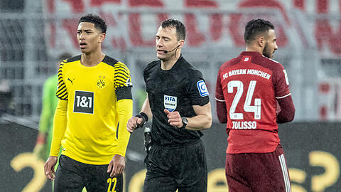 Felix Zwayer (M.) läuft an Dortmunds Jude Bellingham vorbei zum Spielfeldrand, um sich den Videobeweis für den anschließend gegebenen Strafstoß anzuschauen.