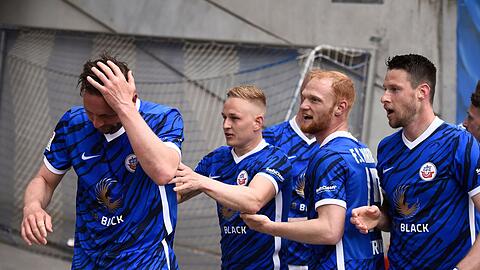 Rostocks Spieler bejubeln John Verhoek (l) nach dessen Treffer zum 2:0.