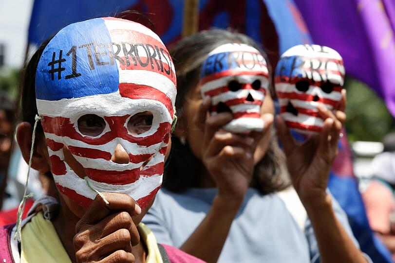 Philippinische Aktivisten tragen Pappmache-Totenschädel mit den Farben der USA vor der US-Amerikanischen Botschaft in Manila. Sie demonstrieren gegen den bevorstehenden Besuch von US-Präsident Barack Obama. Sie fordern das Ende der amerikanischen Militärpräsenz auf den Philippinen.