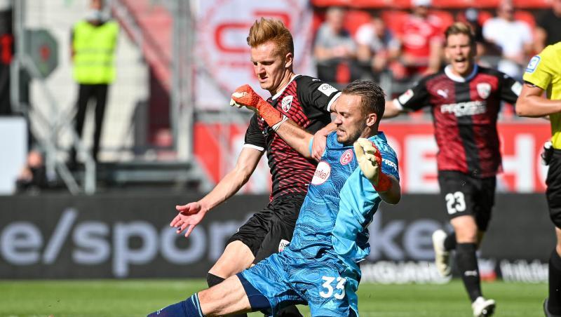 Torwart Florian Kastenmeier von Düsseldorf (r) und Christian Gebauer von Ingolstadt kämpfen um den Ball.