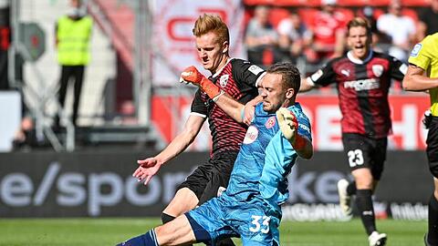 Torwart Florian Kastenmeier von Düsseldorf (r) und Christian Gebauer von Ingolstadt kämpfen um den Ball.