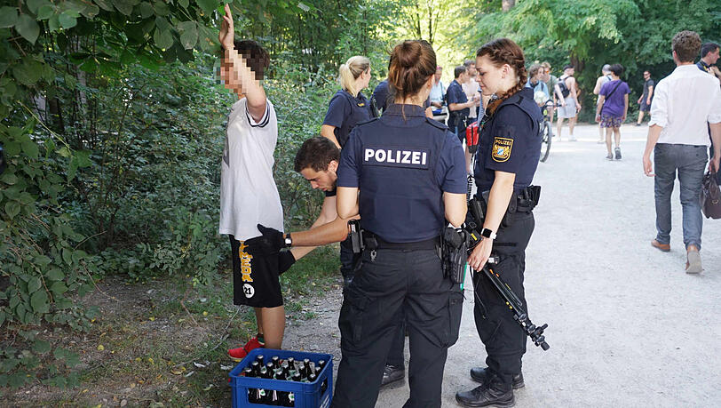Ein junger Mann mit Biertragerl wird durchsucht.