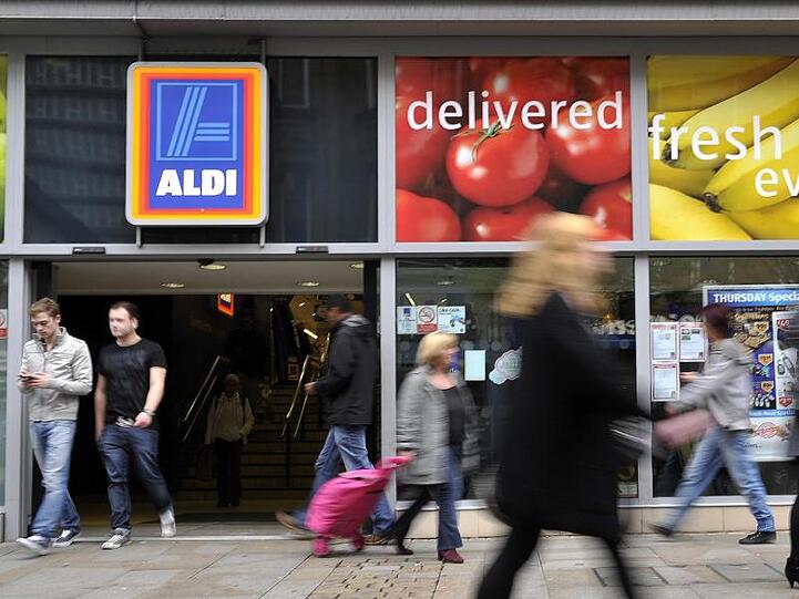 Passanten gehen in der Innenstadt von Manchester, Großbritannien, an einer Filiale von Aldi vorbei.