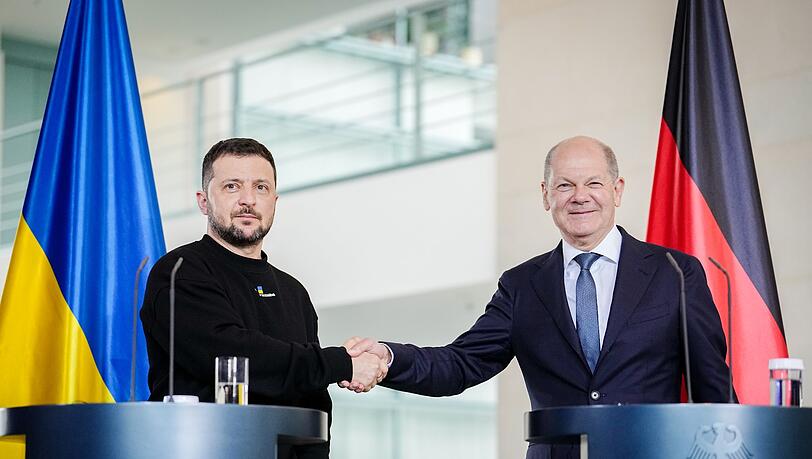 Der ukrainische Präsident Wolodymyr Selenskyj und Bundeskanzler Olaf Scholz (r, SPD) geben sich bei einer Pressekonferenz im Bundeskanzleramt die Hand.