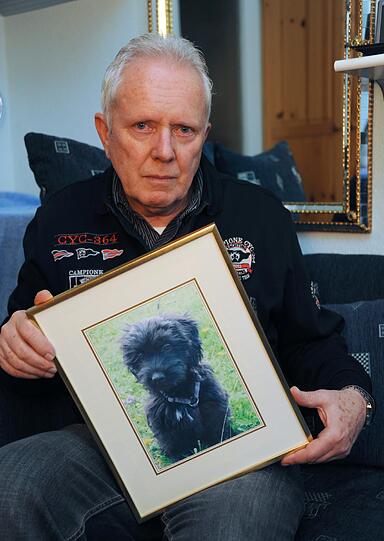 Günther H. mit einem Bild von seinem Welpen. Er wünscht sich nichts sehnlicher, als Tracy zurückzubekommen.
