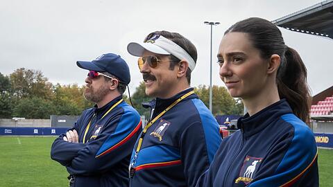 Mit Coach Beard (Brendan Hunt) und der schroffen Alice Chilton (Tanya Reynolds) hat Ted Lasso (Jason Sudeikis, Mitte) zwei hervorragende Co-Trainer an seiner Seite.