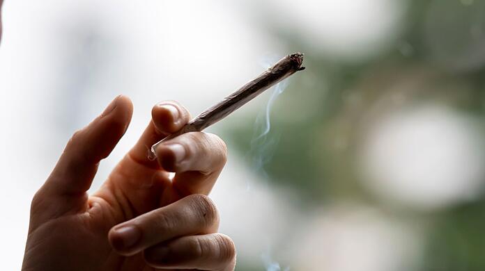 Ein Mann raucht einen Joint.