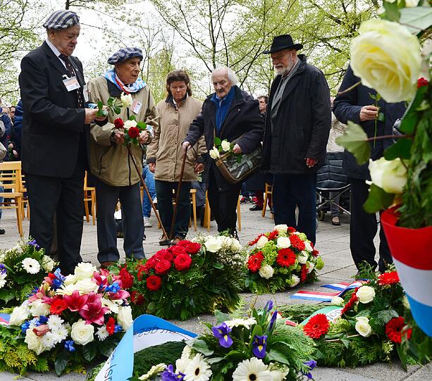 In der KZ-Gedenkstätte Mittelbau-Dora legen die früheren KZ-Häftlinge Alojzy Maciak (l) und Tadeusz Samerdak (2.v.l.) aus Polen in Nordhausen (Thüringen) am Krematorium Blumen nieder, um der Toten zu gedenken. An diesem Tag wird an die Befreiung des nationalsozialistischen Konzentrationslagers vor 69 Jahren erinnert. Im Mittelpunkt des Gedenkens steht in diesem Jahr die Vernichtung der ungarischen Juden.