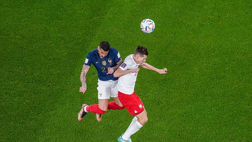 Polens Jakub Kaminski (r) kämpft im WM-Achtelfinale mit Frankreichs Theo Hernandez um den Ball.