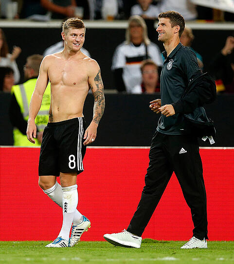 Hilfsbereit, der Herr Müller: Nach dem WM-Qualifikationsspiel der DFB-Elf gegen Norwegen (6:0) gibt Thomas Müller seinem fröstelnden Teamkollegen und früheren Bayern-Profi Toni Kroos seine Trainingsjacke und hält ihm dann auch noch die Ärmel.