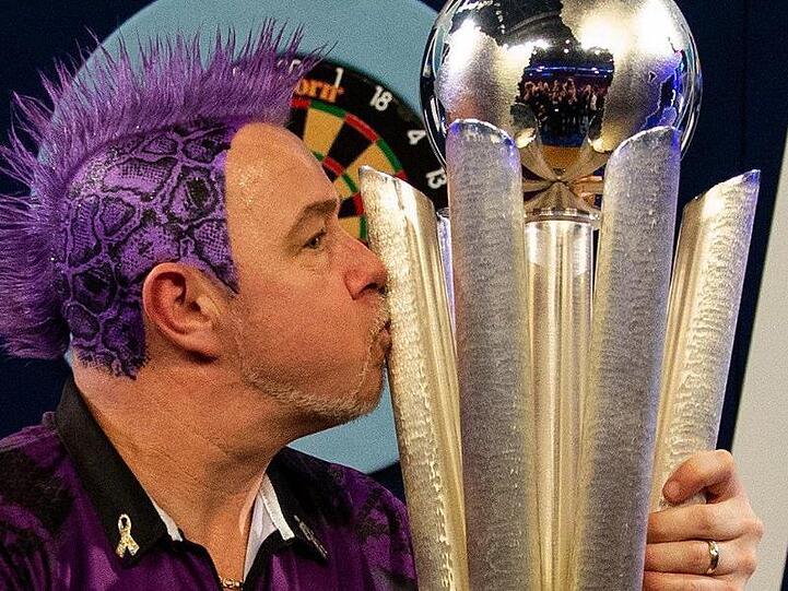 Der schottische Dartspieler Peter Wright herzt nach seinem Sieg die Sid-Waddell-Trophäe.