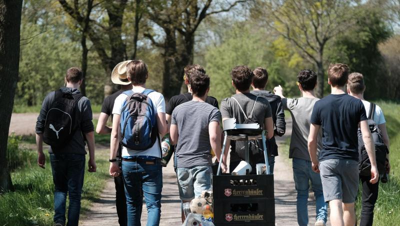 Eine Gruppe junger Männer feiert den Vatertag mit einem mit Bier gefüllten Bollerwagen. Eine Gruppe junger Männer feiert den Vatertag mit einem mit Bier gefüllten Bollerwagen.