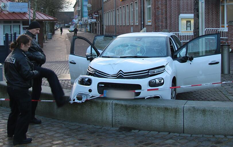 Polizeibeamte nehmen in Cuxhaven das beschädigte Auto in Augenschein. Foto: Jens Potschka/Cuxhavener Nachrichten