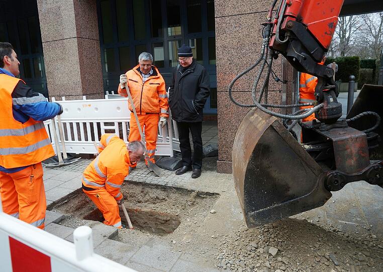 Mitarbeiter des Baureferats verfüllen den Schacht mit Kies und Beton.