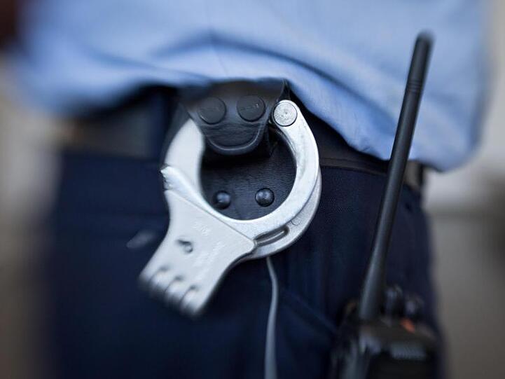 Handschellen hängen am Gürtel eines Justizbeamten. Foto: Friso Gentsch/dpa/Symbolbild