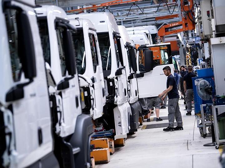 Mitarbeiter von MAN Truck & Bus arbeiten an einer Produktionsstraße an einem LKW. Foto: Sven Hoppe/dpa/Archivbild