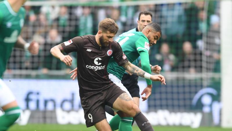 Pauli-Torjäger Guido Burgstaller (vorne) schirmt den Ball gegen Werders Jean Manuel Mbom ab.