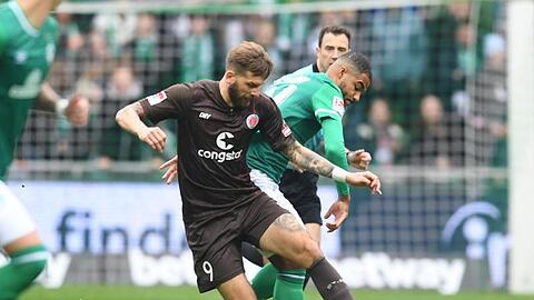 Pauli-Torjäger Guido Burgstaller (vorne) schirmt den Ball gegen Werders Jean Manuel Mbom ab.