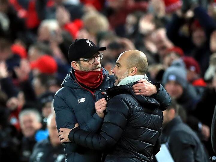 Liverpools Trainer Jürgen Klopp (l) und Man-City-Coach Pep Guardiola umarmen sich nach dem Abpfiff.