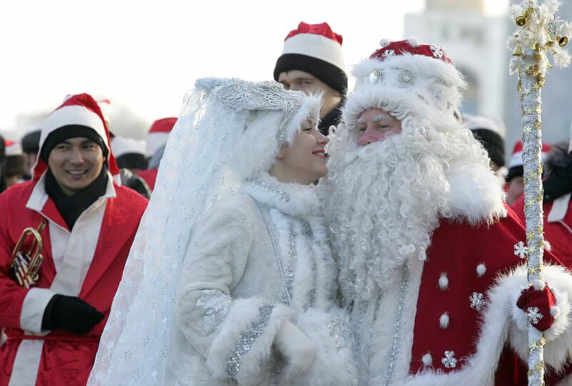 Die Menschen nehmen an einer Parade in Kirgisistan teil. Sie verkleiden sich traditionell als "Väterchen Frost" und seine Enkelin.