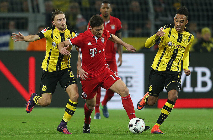 Bayerns Xabi Alonso (Mitte) versucht, den Dortmundern Marcel Schmelzer (rechts) und Pierre-Emerick Aubameyang zu enteilen.