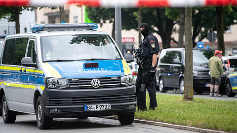 Ein schwer bewaffneter Polizeibeamter am Tatort im Norden von München.