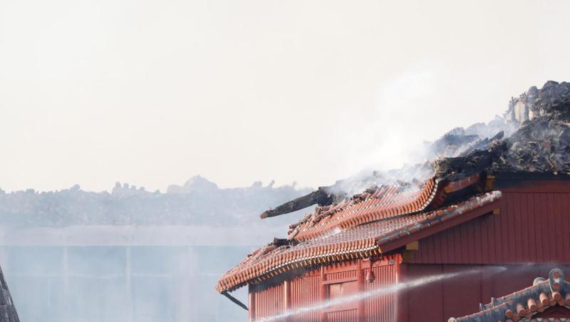 Feuerwehrleute versuchen einen Brand der historischen Shuri Burg zu löschen. Feuerwehrleute versuchen einen Brand der historischen Shuri Burg zu löschen.