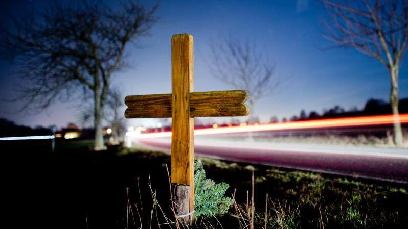 Ein Kreuz zur Erinnerung an einen Verkehrstoten steht an einer Landstraße. Foto: Julian Stratenschulte/Archivbild