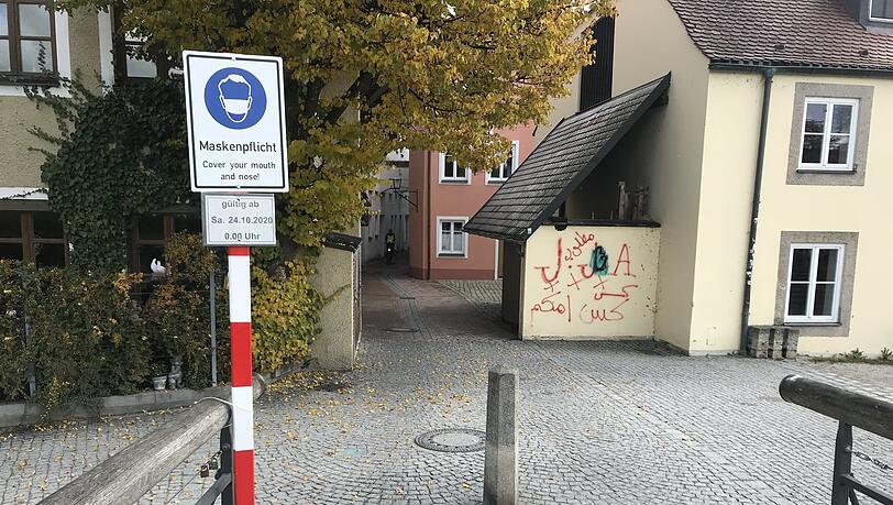 Ein Schild weist auf die Maskenpflicht hin. Ein Schild weist auf die Maskenpflicht hin.