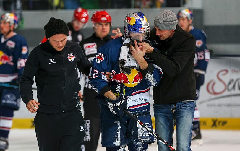 Zwei medizinische Betreuer führen EHC-Star Jeremy Dehner vom Eis, der im Berlin-Spiel von einem Puck im Gesicht getroffen wurde.