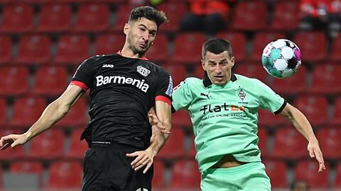 Lucas Alario (l) kämpft mit Mönchengladbachs Verteidiger Stefan Lainer um den Ball.