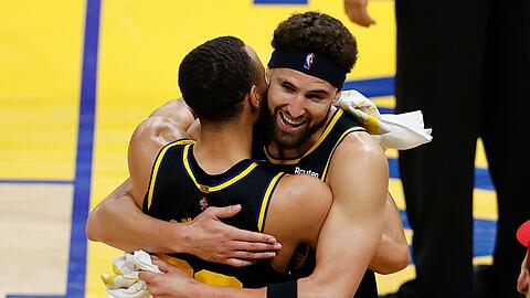 Klay Thompson (r) umarmt Stephen Curry nach dem Sieg der Warriors gegen die Dallas Mavericks.