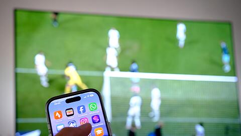 Nebenbei mal daddeln: W&auml;hrend das Fu&szlig;ballspiel l&auml;uft, schauen viele Zuschauer nebenbei aufs Handy. (Symbolbild)