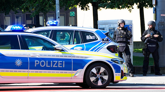 Polizisten sind in München im Einsatz: An den Straßensperren stehen mit Maschinenpistolen bewaffnete Beamte.