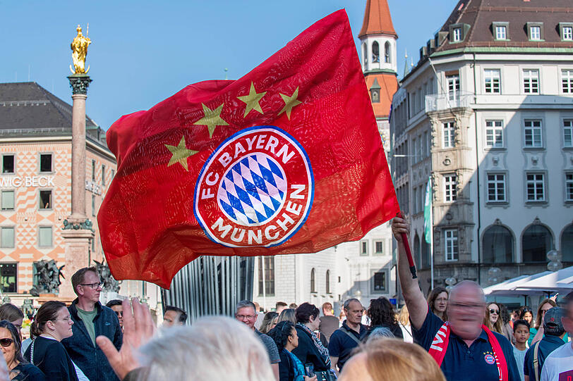 Ein Bayern-Fan schwenkt kurz nach Titelgewinn die Fahne auf dem Marienplatz am Sonntag, 28. Mai 2023.