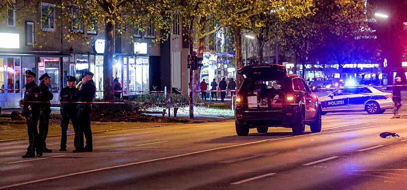 Polizisten stehen an einem mit Absperrband umgebenen schwarzem Jeep auf der Wandsbeker Chaussee.