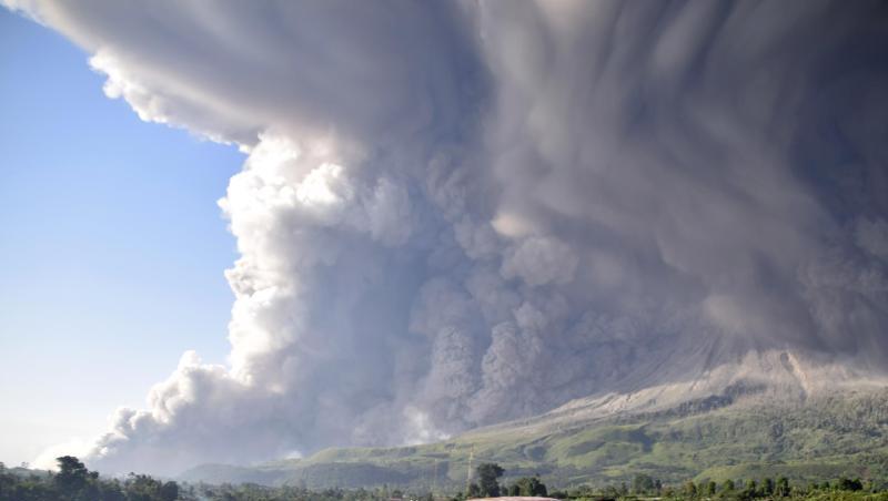 Menschen beobachten eine Eruption des Vulkans Sinabung.